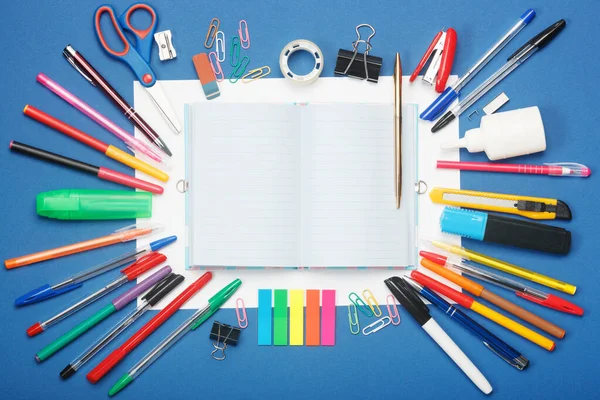 Stationery and blank notebook on blue background. Education concept with copy space for your ideas. — Stock Photo, Image