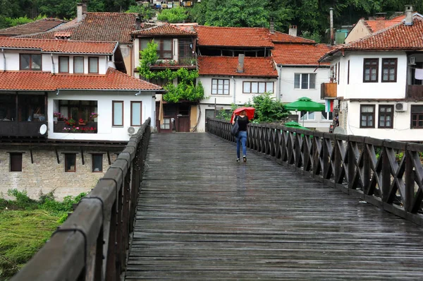 Леди с красным зонтиком на деревянном мосту — стоковое фото