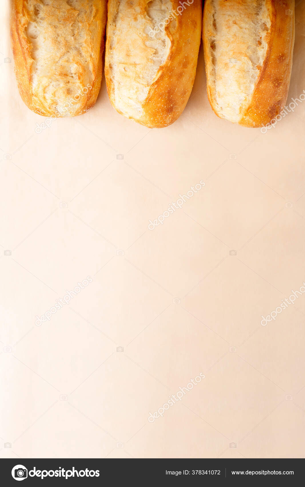 French baguettes in a row on light brown background with copy