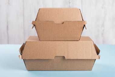 Birbirinin üstünde duran iki farklı boyutta hamburger kutusu.