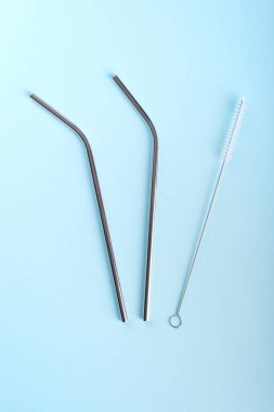 Paslanmaz çelik. Açık mavi arka planda küçük fırçalı pipetler.