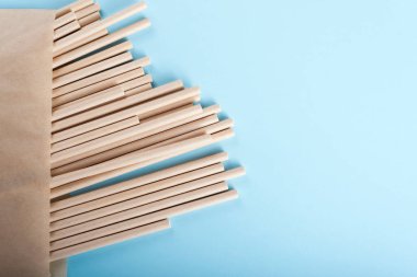 Kağıtlar açık mavi arkaplandaki kese kağıdında pipet içerler.. 