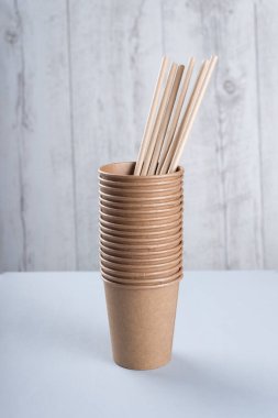 Biyolojik çözünebilir fincanlar ve açık gri arka planda pipet içmek