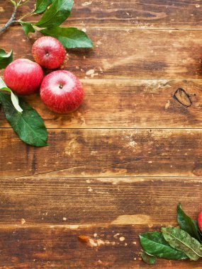 Olgun kırmızı elma ile ahşap arka plan yapraklarda. Sığ dof.