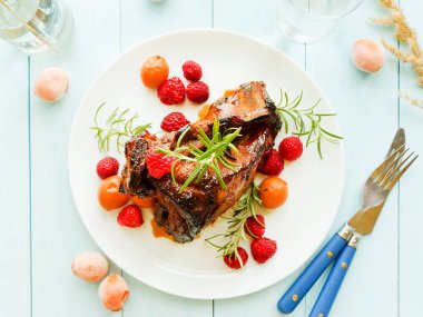 Kızarmış domuz kaburga ahududu ve biberiye ile. Sığ dof.