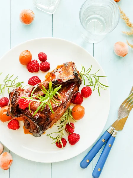 Kızarmış domuz kaburga ahududu ve biberiye ile. Sığ dof.