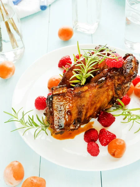 Kızarmış domuz kaburga ahududu ve biberiye ile. Sığ dof.