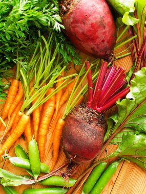 Pancar kökü, havuç ve yeşil bezelye ahşap arka plan. Sığ dof.