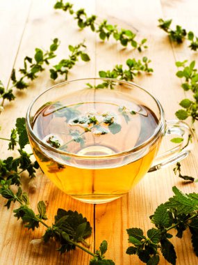 Beyaz ahşap arka planda bir fincan Melissa çayı..