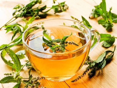 Beyaz ahşap arka planda bir fincan nane çayı..