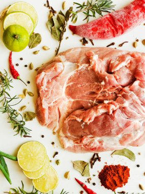Beyaz ahşap arka planda baharatlı ve otlu taze domuz eti. Sığ dof.