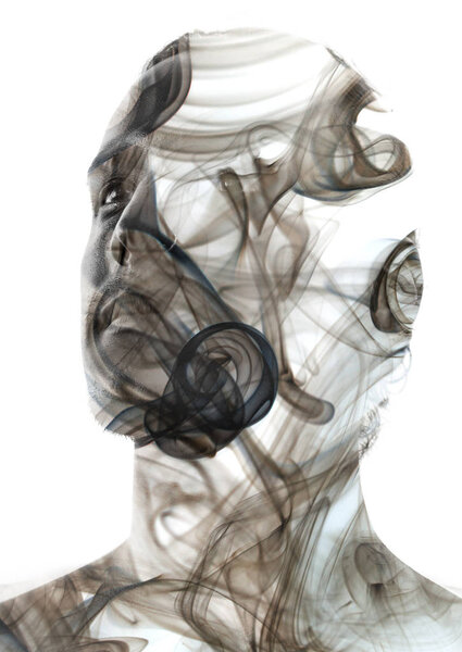 Уникальная концептуальная работа, объединяющая непредсказуемый характер вихревого дыма с твердым взглядом молодого привлекательного мужчины
