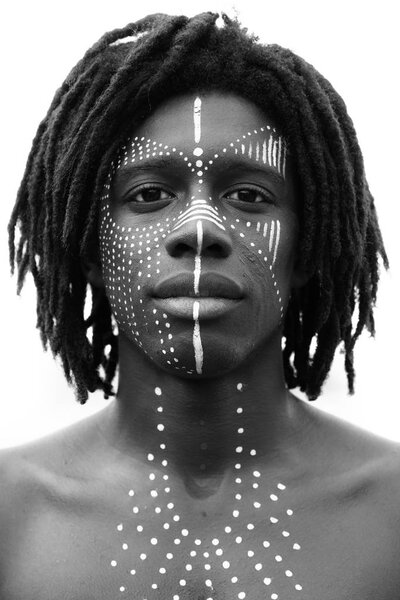 Portrait of young african man with dreadlocks and traditional fa