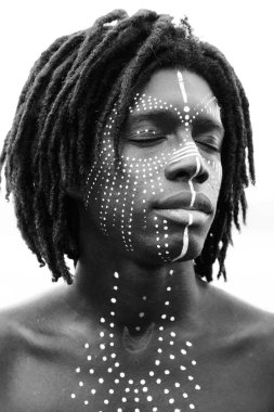 Portrait of young african man with closed eyes and traditional f clipart