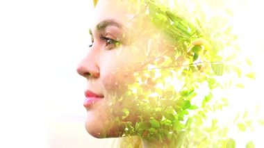 Barışçıl kadının yakın çekim üzerinden geçen rüzgarda yeşil yaprakların çift pozlama video