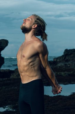 Atletizm sporcusu dışarıda fotoğraf çalışıyor.