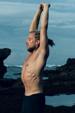 Atletizm sporcusu dışarıda fotoğraf çalışıyor.