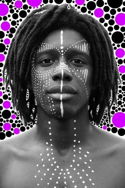 Porträt eines jungen Afrikaners mit Dreadlocks und traditioneller Gesichtsbemalung, der direkt in die Kamera blickt — Stockfoto