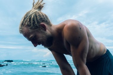 Bir kayanın üzerinde antrenman yapan bir sporcu. 