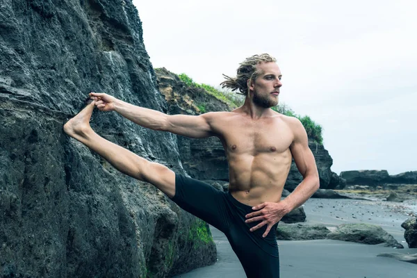 Atleet man oefenen op een zwart zandstrand — Stockfoto