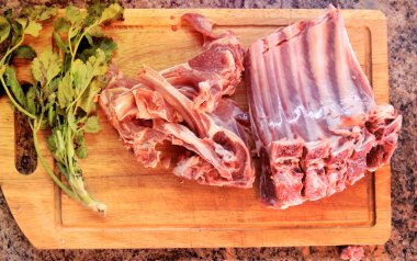 kesme tahtası taze kuzu kaburga ile rosemary ile dekore edilmiştir.