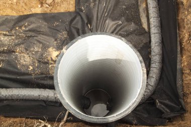 close up top view of drainage pipes and inspection well for removal of water from a site under construction of the house clipart