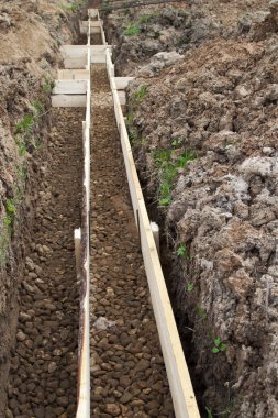 tedavi edilmemiş kalıp panoları ve moloz çukurun dibinde görünümünü kuruluşu altında kazdık