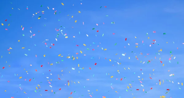 Mångfärgade Konfetti Klarblå Himmel Bakgrund Begreppet Holiday Bakgrund — Stockfoto