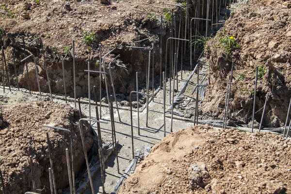 first stage of pouring the Foundation for a new building with cement and reinforcements with steel bars and wire rod