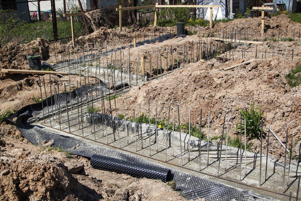 first stage of pouring the Foundation for a new building with cement and reinforcements with steel bars and wire rod