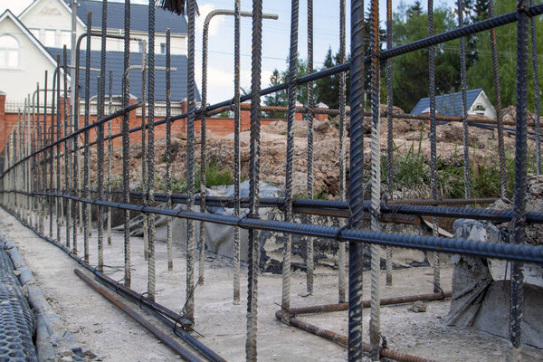 first stage of pouring the Foundation for a new building with cement and reinforcements with steel bars and wire rod