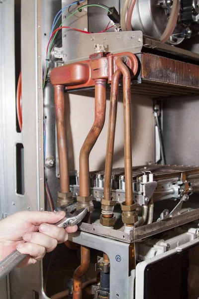 Worker installs the heat exchanger after descaling on a workplace in the gas boiler — Stock Image Worker Installs Heat Exchanger Descaling Workplace Gas Boiler Royalty Free Stock Photos