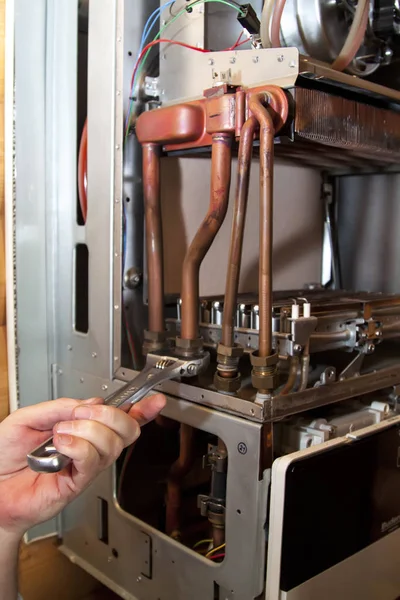 Worker installs the heat exchanger after descaling on a workplace in the gas boiler — Stock Image Worker Installs Heat Exchanger Descaling Workplace Gas Boiler Stock Photo