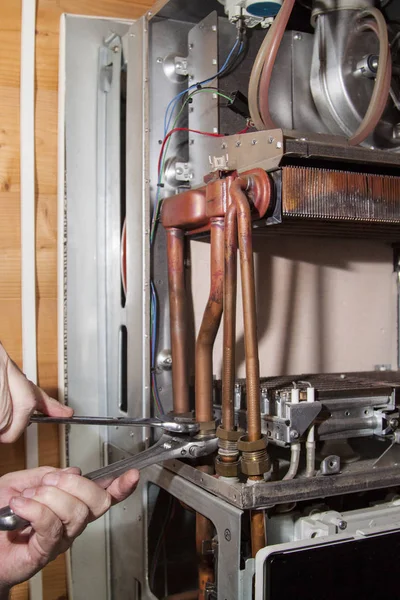 Worker installs the heat exchanger after descaling on a workplace in the gas boiler — Stock Image Worker Installs Heat Exchanger Descaling Workplace Gas Boiler Royalty Free Stock Photos