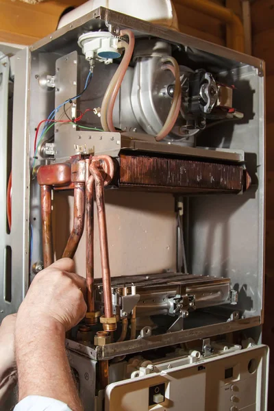 Worker installs the heat exchanger after descaling on a workplace in the gas boiler — Stock Image Worker Installs Heat Exchanger Descaling Workplace Gas Boiler Royalty Free Stock Images
