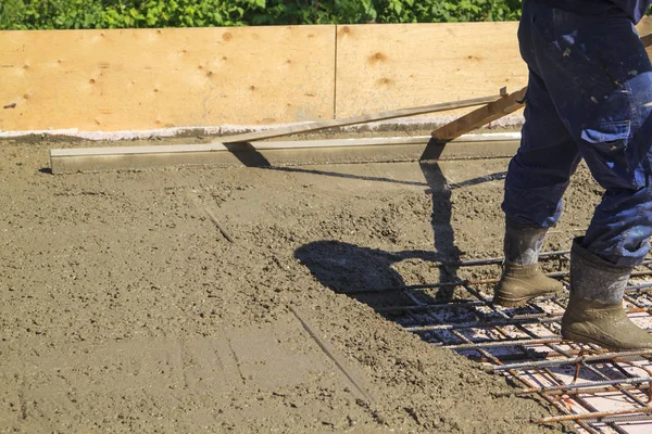 Trabalhador nivelamento laje de concreto fresco com uma ferramenta de trabalho especial — Fotografia de Stock