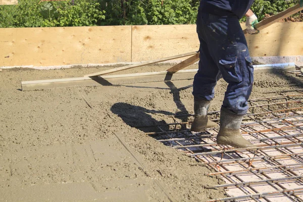 Trabalhador nivelamento laje de concreto fresco com uma ferramenta de trabalho especial — Fotografia de Stock