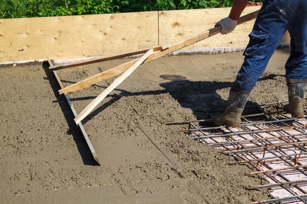 Trabalhador nivelamento laje de concreto fresco com uma ferramenta de trabalho especial — Fotografia de Stock