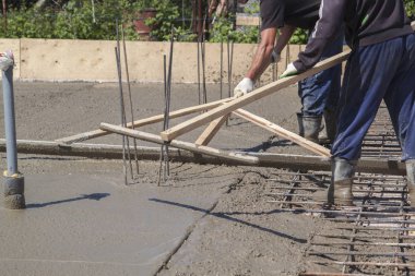 özel bir ahşap w ile taze beton levha tesviye iki işçi