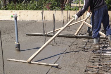 işçiler özel bir ahşap worki ile taze beton levha tesviye