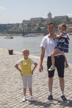 İki çocuklu mutlu baba Tuna kıyısında duruyor