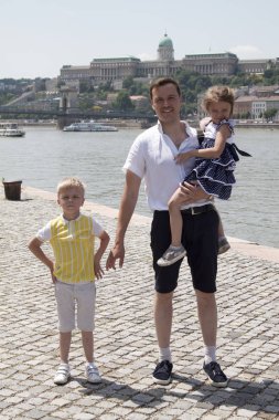 İki çocuklu mutlu baba Tuna kıyısında duruyor