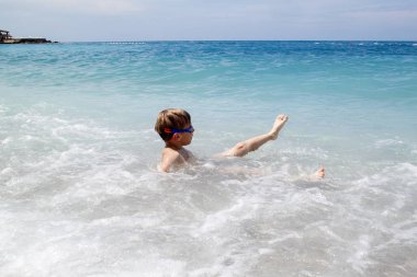 çocuk denizin splahes dalgaları ile oynamak