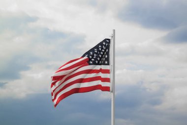 Bulutlar arka plan ile mavi bir gökyüzünde Amerikan bayrağı