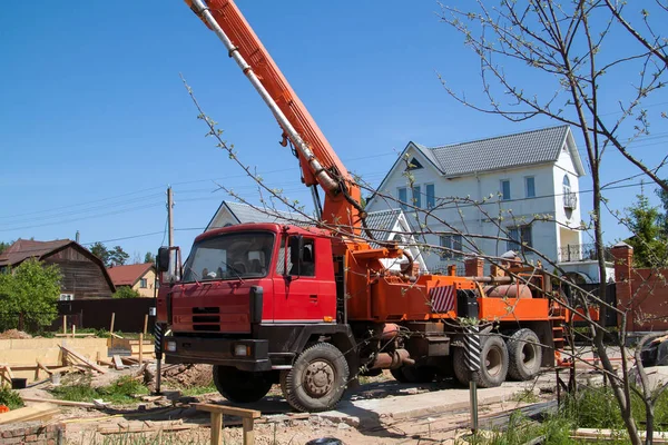 Pompe à béton sur le site contre la dalle de foudation — Photo