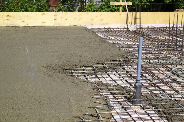 Pouring concrete into prepared place with reinforced metal frame — Stock Photo, Image