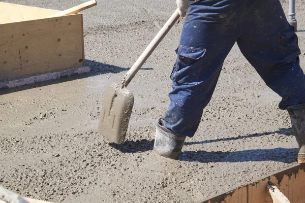 Worker leveling fresh concrete slab with a special working tool — Stock Photo, Image