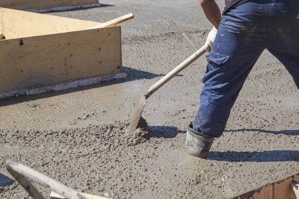 Werknemer nivelleren verse betonnen plaat met een speciale werktuig — Stockfoto