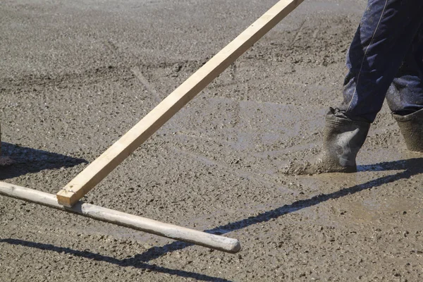 Trabalhador nivelamento laje de concreto fresco com uma ferramenta de trabalho especial — Fotografia de Stock