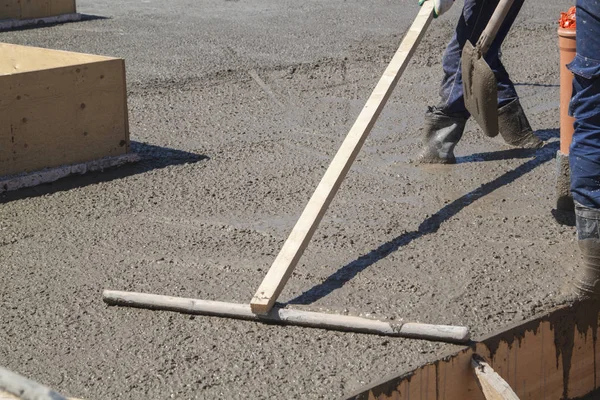 Worker leveling fresh concrete slab with a special working tool — Stock Photo, Image